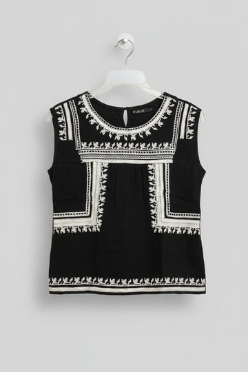 Black dress with white embroidery on a hanger against a colorful background